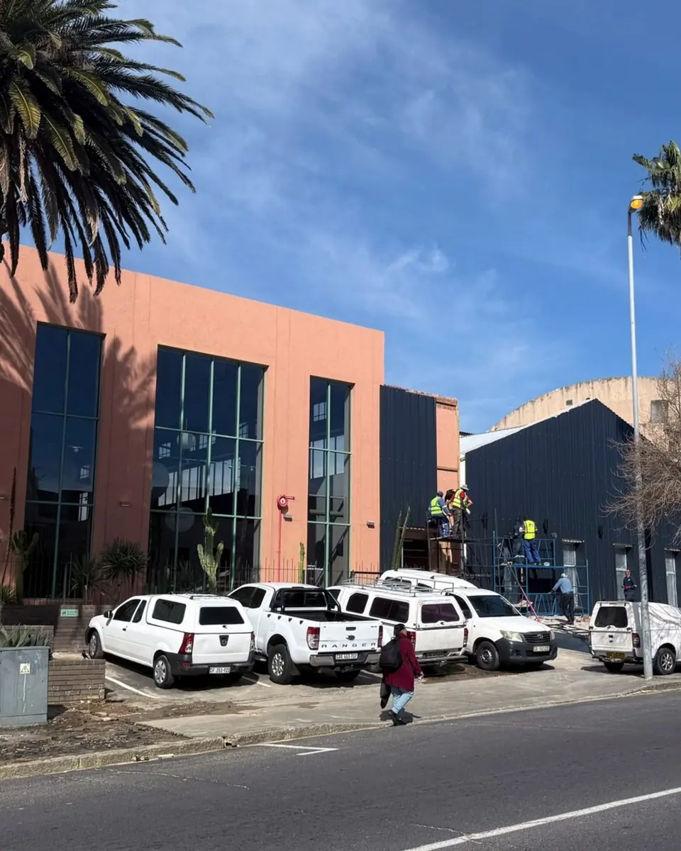 Haldane on Salt River Road: a terracotta and black building with full-height glazing and palm trees