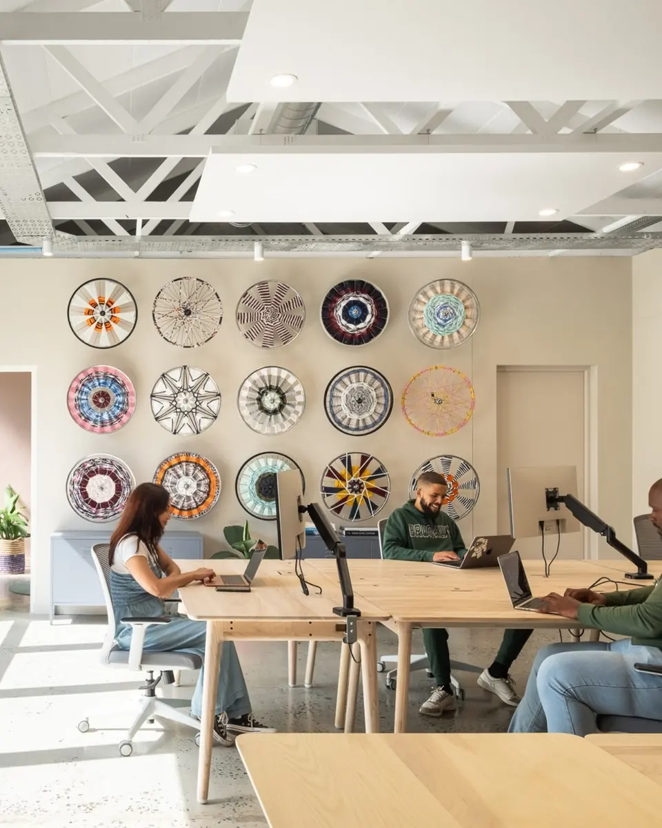 A sunlit co-working floor at 20 Kloof Street with woven baskets on the wall