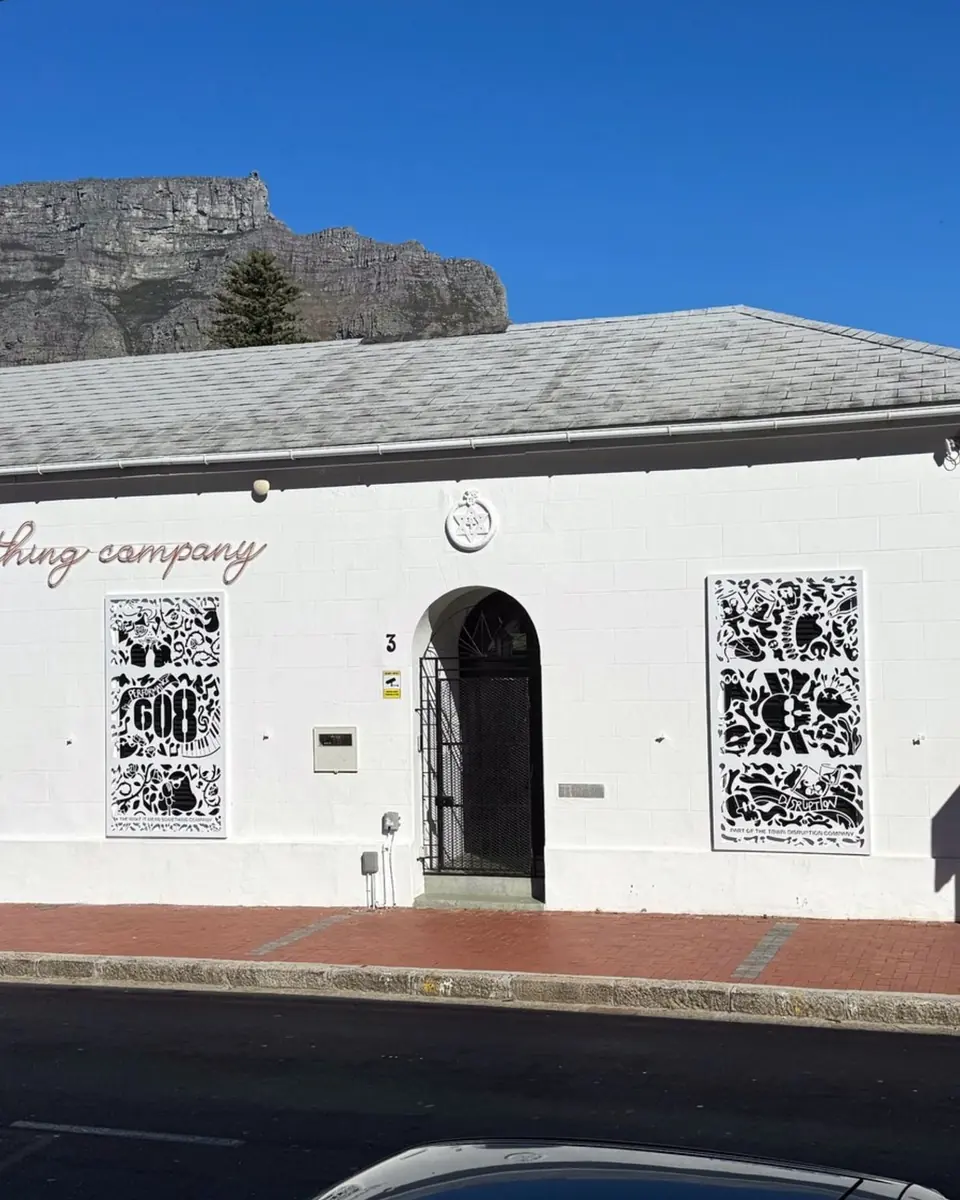 The restored white façade of 3 Rheede Street with Table Mountain behind